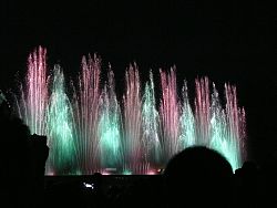 Das Bild zeigt Impressionen vom Wasserspiel "Wasserfee". Zu sehen sind grün-rote Fontänen.